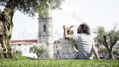 一对<strong>情侣在公园</strong>草地上的树旁接吻